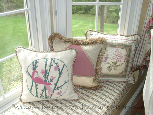 Needlepoint Pillow of a pink bird among green branches with pink blossoms. Window seat cushion and pillows designed by Window Designs Etc. in Sterling, MA