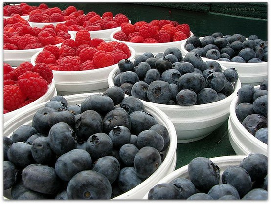 4th of July red, white and blue. White bowls with blueberries and red raspberries
