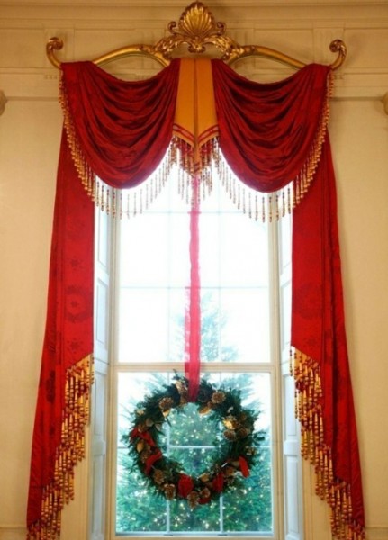 Dramatic red and gold window treatment with Christmas wreath. Holiday window decorating ideas. See more at www.windowdesignsetc.com