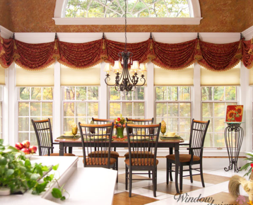 Window valance across multiple windows in a rust and gold swagged fabric creates a unique custom top treatment for a Worcester, MA dining area.